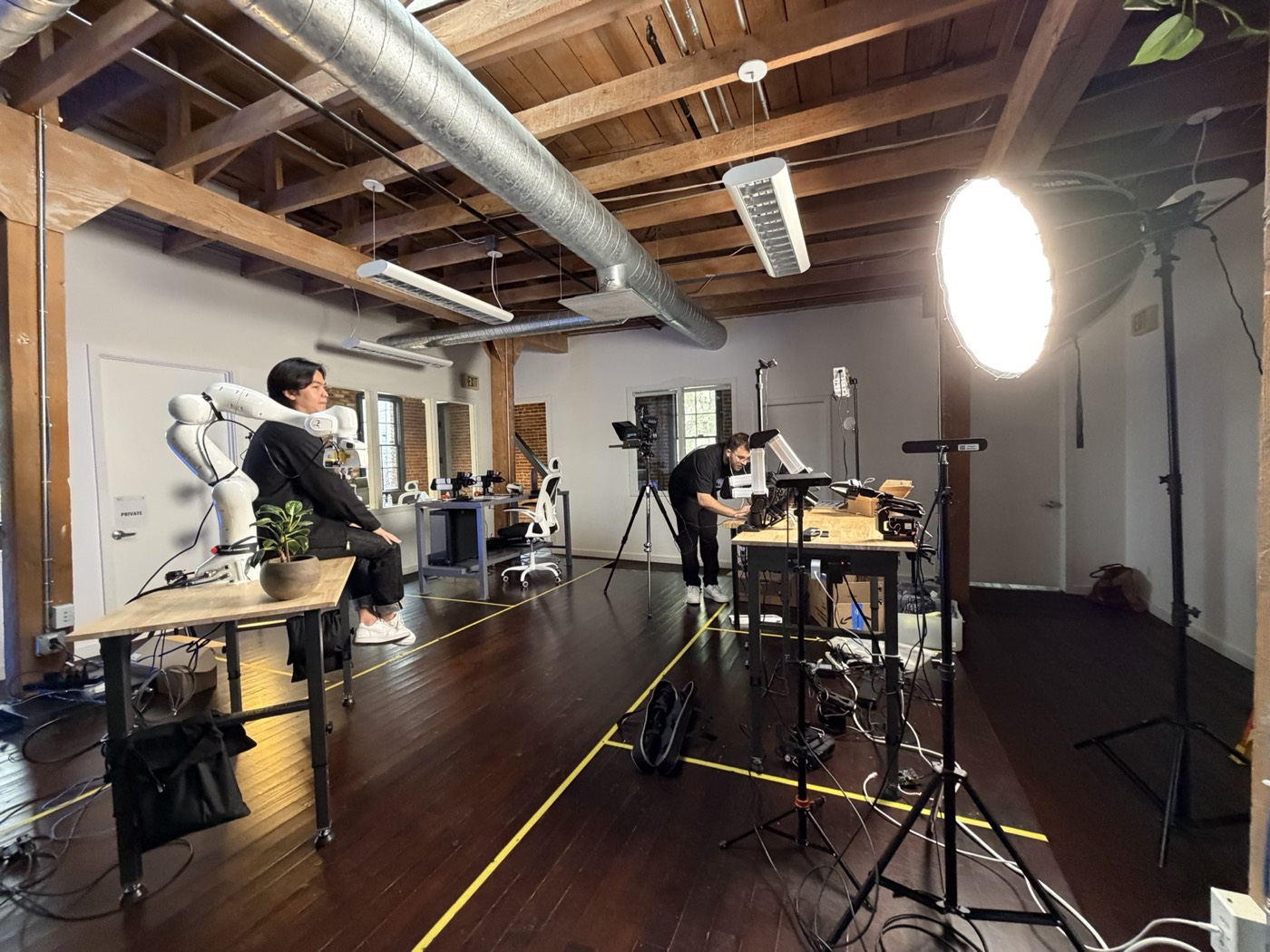 A shoot in progress on the floor — lighting rig up, arm rigged on the bench